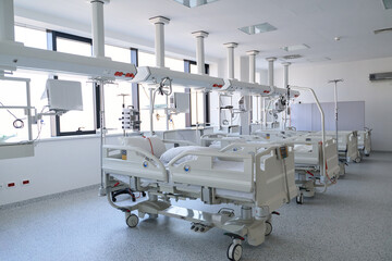 Modern hospital room with multiple patient beds and medical equipment in bright, clean environment