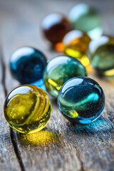 Glowing marbles with various colors on a wooden surface, symbolizing beauty and uniqueness.