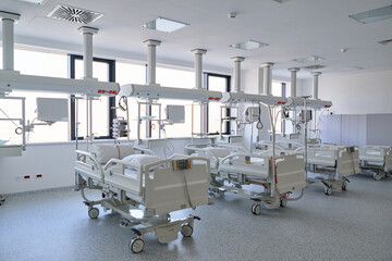 Modern hospital ward with multiple beds and advanced medical equipment in bright, clean environment