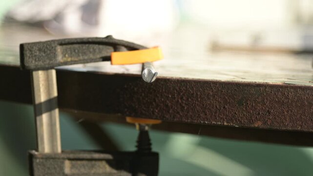 Grinder blade cutting through metal rod flashing sparks close-up, level side view