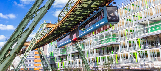 Panorama of the historic Schwebebahn train in front of a modern building in Wuppertal, Germany