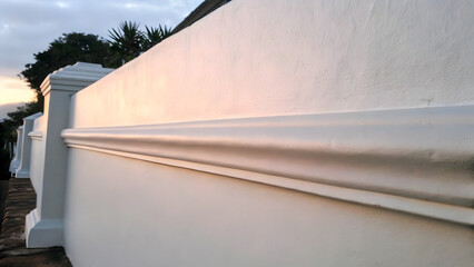 Angled View of Building with Horizontal Siding Panels and Paved Ground in Architectural Exterior Scene