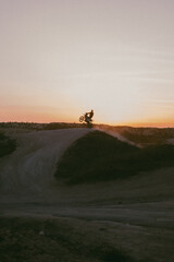 silhouette of a man riding a bike, whillie, stunt