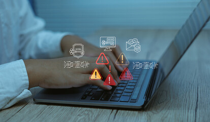 Businessman typing using laptop with digital warning icons alerts and security symbols Concept of cybersecurity risk system error data email protection, malware detection information technology safety