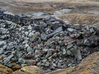 Crumbled pieces of solidified lava, close up. Valahn&uacute;kam&ouml;l, wild terrain with layers of black volcanic ash and dark basalt stone. Coast of Atlantic ocean in the edge of Reykjanes Peninsula in Iceland.
