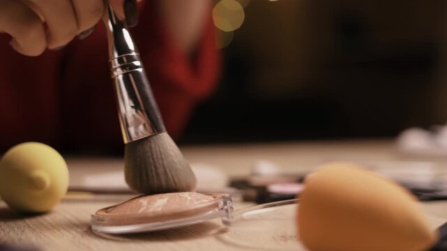 Brush puts in brown-beige bronzer for make-up. Cosmetic, powder, bronzer