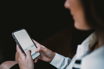 Cheerful girl typing on mobile phone while leaning against wall, representing authentic joy in everyday digital interactions and communication.