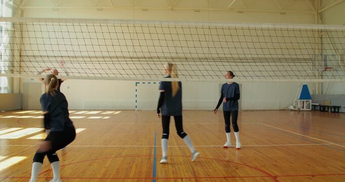 The team celebrates the point they earned after an intense game.. In a 3-on-3 format, the girls actively serve, return, and pass the ball to each other, creating a dynamic game on the court.