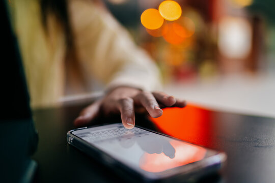 Young woman holds smartphone while carrying a tablet and stylus, capturing mobile multitasking and digital workflow in a modern tech‑driven moment. - Powered by Adobe