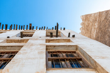 Weathered traditional Arabian architecture under a clear blue sky, featuring textured mud walls and windows. Perfect for travel and heritage themes © serebryannikov
