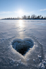 heart shaped hole in the ice of a lake, sunny winter day, love, passion, romance, romantic, portrait format, photorealistic