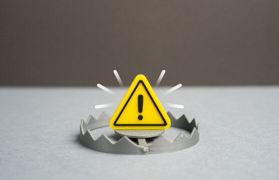 A warning sign above a trap. A warning of a trap and danger. Finance and technology risks, hidden threats, poor decisions and the need for awareness and preventive risk management