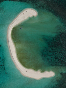 Aerial view of the pristine white sandbar curving gracefully in the turquoise sea, Mambajao, Camiguin, Philippines.
