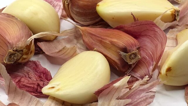 Fresh garlic cloves rotating, clean eating and timeless kitchen essentials
