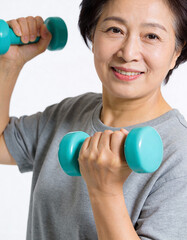 Asian senior woman exercising with dumbbells, healthy lifestyle concept.
