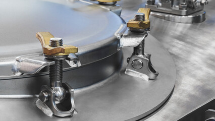 Part of a large chemical pharmaceutical machine, a stainless steel container covered with a bolted...