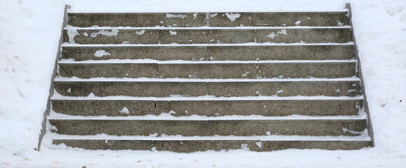 The steps of the stone staircase cleared of snow