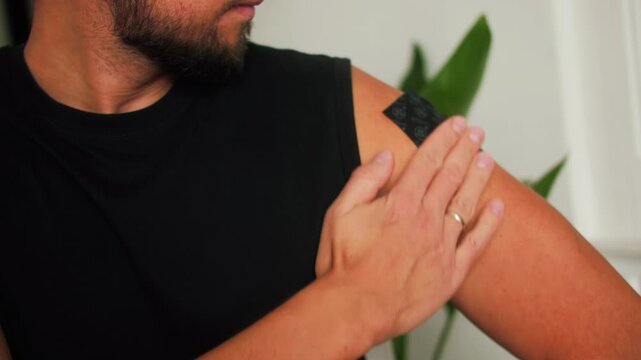 Close-up of a man applying a nicotine contraceptive patch to quit smoking, a person struggles with his addiction. High quality 4k footage