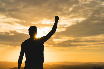 Fototapeta premium Strong man with fist up into the sky. Competition, determination and finding strength concept. 