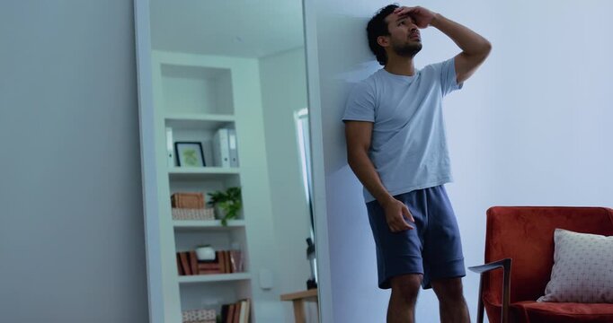 Mirror, mental health and sad man with despair in home, disappointed or negative self esteem crisis. Hopeless feeling, unhappy or frustrated person with depression, reflection or upset for body image