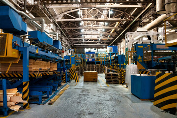 Interior of manufacture plant with stock wood treatment on automatic machinery, woodwork. Wood treatment process of plywood in industrial factory. Woodwork plywood industry concept. Copy ad text space © Aleksandr