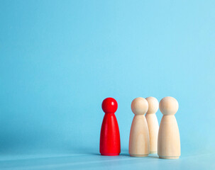 Red wooden figure leading a group of pawns