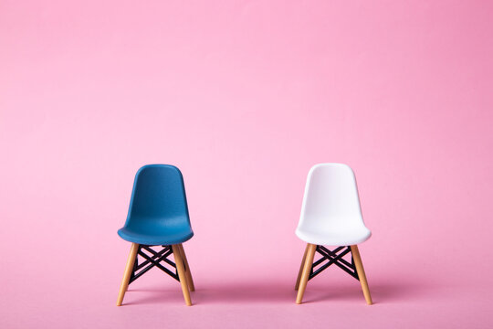 Two eames style chairs on pink background