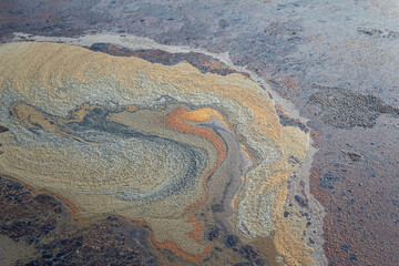 Contaminated sewage dirty fluid mix with chemical or crude oil, it floating on water surface at public water place. Environmental issue from industrial. Close-up