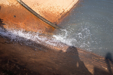 Contaminated sewage dirty fluid mix with chemical or crude oil is draining into public water place. Environmental issue from industrial.