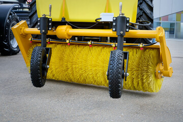Tractor with attachments for sweeping works on a city street.