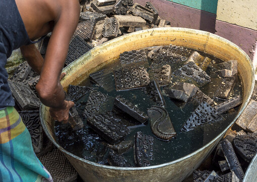 Bangladeshi man washing wooden block prints, Dhaka Division, Rupganj, Bangladesh