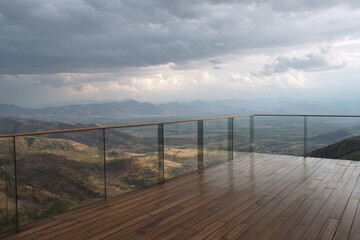 Obraz premium Wooden deck overlooks valley, mountains, and stormy sky. Glass railing provides safety