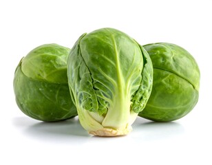Three small, round, green cabbages, possibly sprouts, sit on a plain white backdrop. The central one is focused