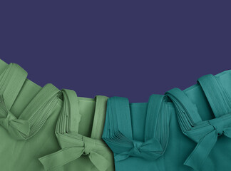 Green and blue polypropylene bag on a soft blue background. Non-woven fabric tote bag with space for text. Eco-friendly bag.