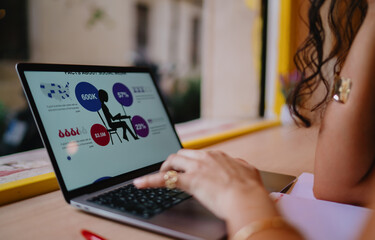 Hands of freelancer working on laptop screen with infographics, reflecting visual data processing, digital engagement, and conceptual thinking through tech.