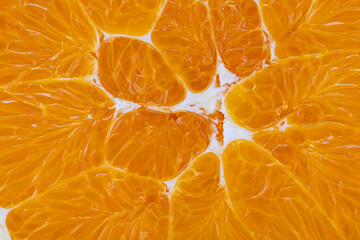Close view of segmented orange fruit showing texture and color in bright light