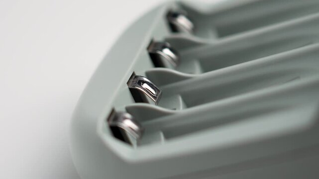 Empty AAA battery charger with steel contacts close up