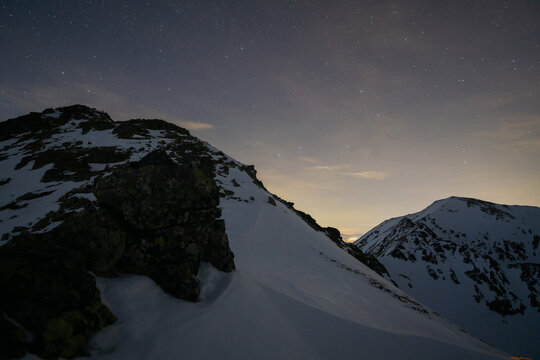 View of a snow-dusted peak under a starlit sky, where the cold, crisp air bites and the silence is broken only by the whisper of the wind, Pribylina, Zilina Region, Slovakia.