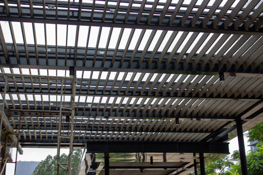 Detail of a modern aluminum louver roof structure with downlight lighting and steel scaffolding at a building in Alam Sutera.