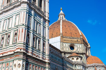 Detailed view of Santa Maria del Fiore cathedral in Florence, showing the iconic red dome and the nearby bell tower, highlighting the rich Renaissance architecture and historic elegance.