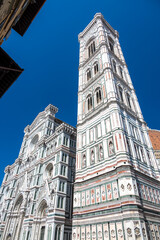 Detailed view of Santa Maria del Fiore cathedral in Florence, showing the iconic red dome and the nearby bell tower, highlighting the rich Renaissance architecture and historic elegance.
