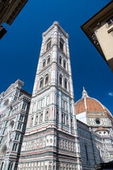 Detailed view of Santa Maria del Fiore cathedral in Florence, showing the iconic red dome and the nearby bell tower, highlighting the rich Renaissance architecture and historic elegance.