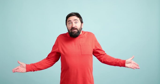 Confused and uncertain bearded man shrugging shoulders