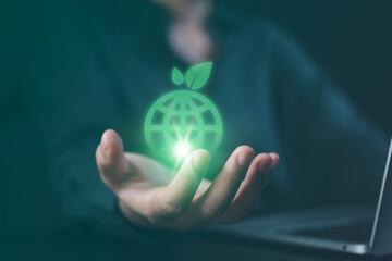 Hand holding a glowing green world globe with leaves. Representing environmental sustainability, ESG criteria, eco-friendly business, and global green energy conservation concepts