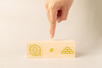 Hand pointing at wooden blocks showing Bitcoin symbol equal to gold bars. Concept of cryptocurrency as digital gold, financial investment, asset valuation, and future of decentralized currency.