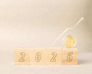 Golden Bitcoin on 2026 wooden blocks with white rising arrow graph. Concept of cryptocurrency price prediction, financial forecast, future investment trends, and bullish market growth in year 2026.