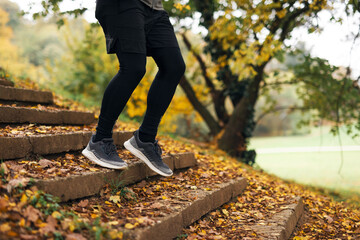 Obraz premium Man exercising on park stairs during autumn