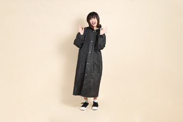 20s Asian woman wearing raincoat