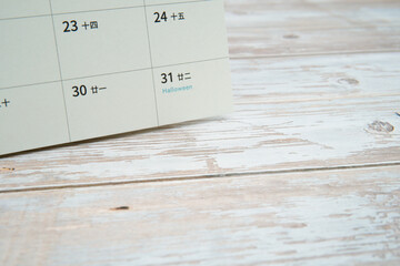 Minimal calendar page at end of month on wooden desk with copy space. Concept of time passing, monthly planning, schedule management, deadline, and clean background.