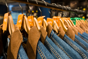 Paris, France - 01 10 2026: Men's blue and brown jackets hanging on hangers with sale tags in a...